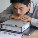 employe assis devant bureau dossier medical refuse par assureur