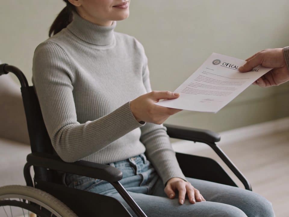 Femme en fauteuil roulant recevant un courrier officiel