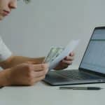 jeune adulte assis au bureau examinant ses factures