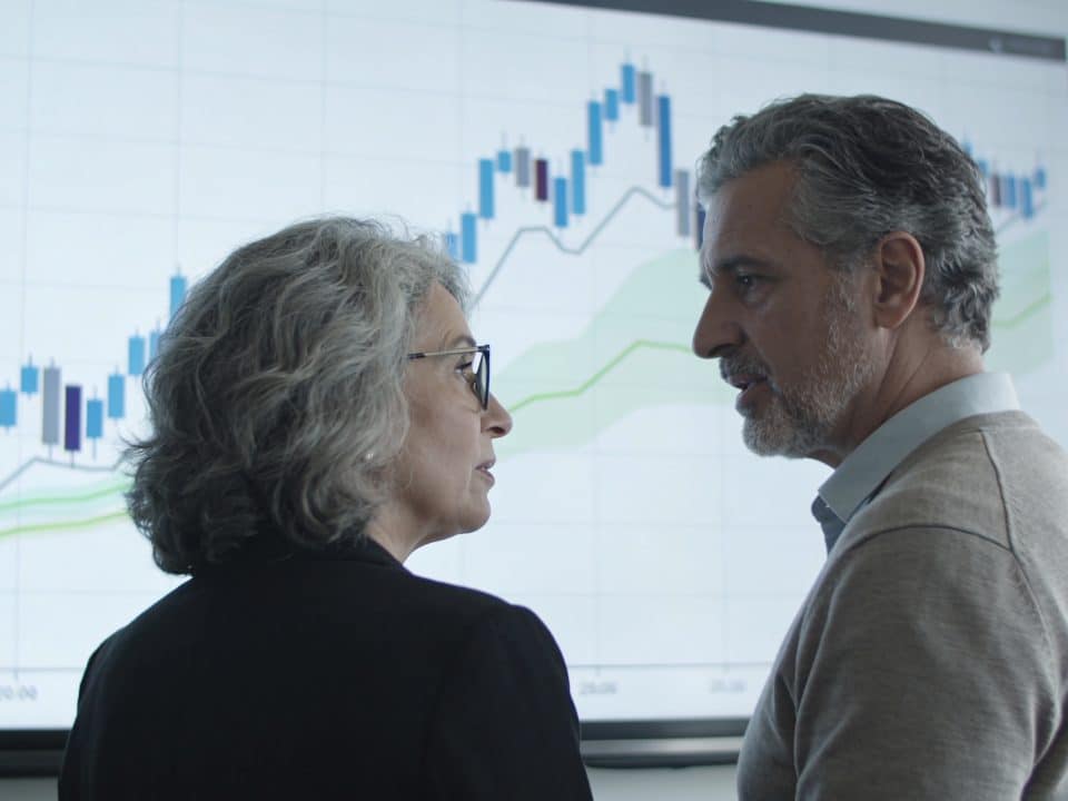 couple age mur discutant devant graphique financier couleur