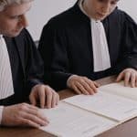 deux notaires assis cote a cote examinant un testament