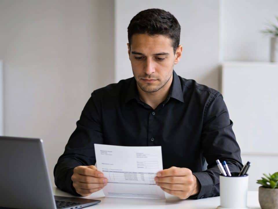 employe italien assis au bureau regardant fiche de paie