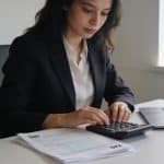 femme assise a un bureau calculant des allocations
