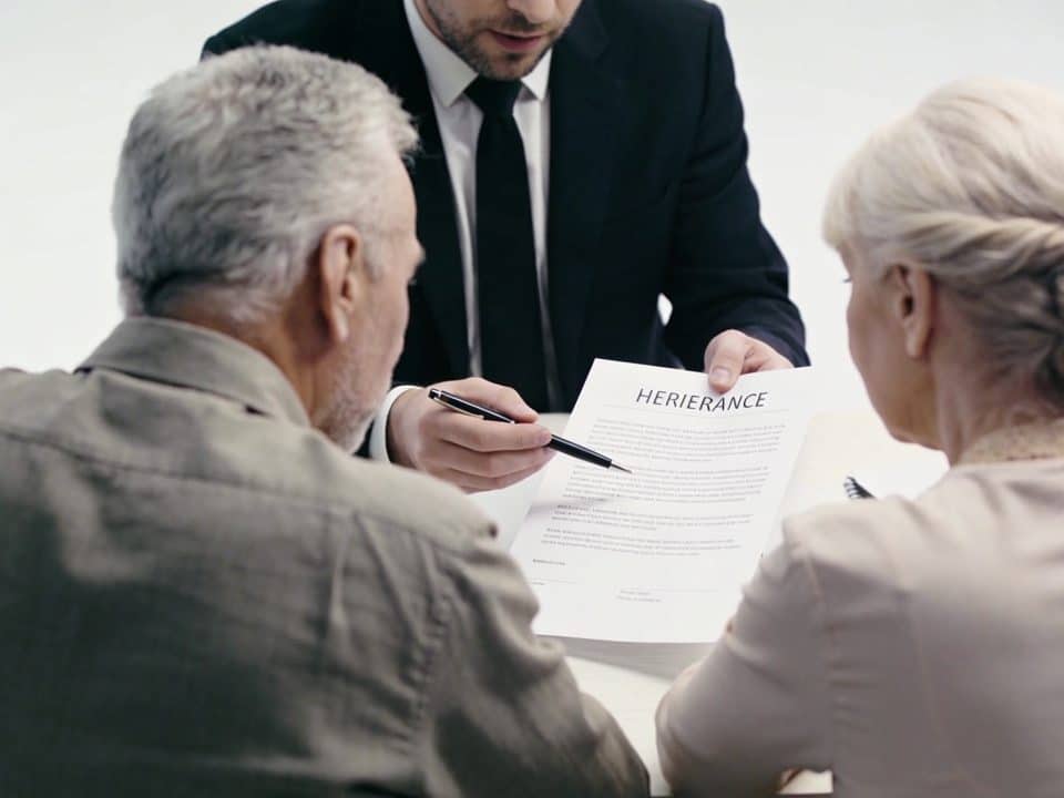 Notaire et couple senior assis discutant documents héritage