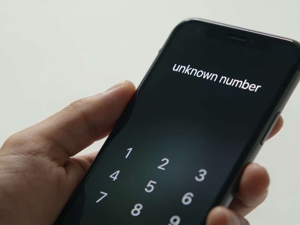 smartphone en main affichant un numero inconnu